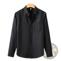 Black men’s linen long-sleeved sun protection shirt with chest pocket hanging on wooden hanger