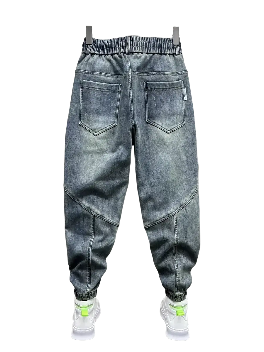 Mens loose denim harem pants in gray with a relaxed fit, elastic waistband, and neon green accented cuffs