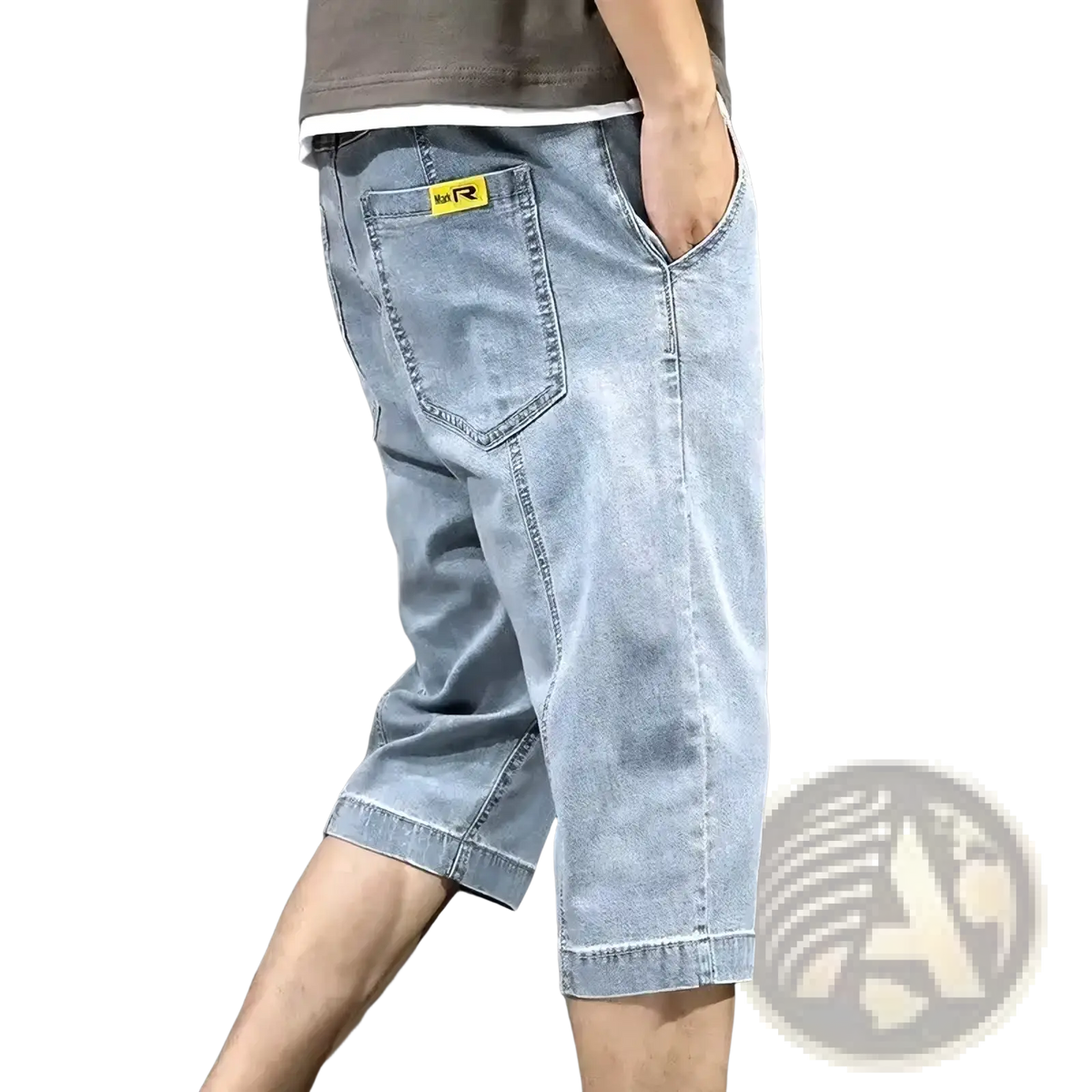 Back side of men’s loose light-wash denim shorts with a yellow brand patch on the back pocket for summer casual wear