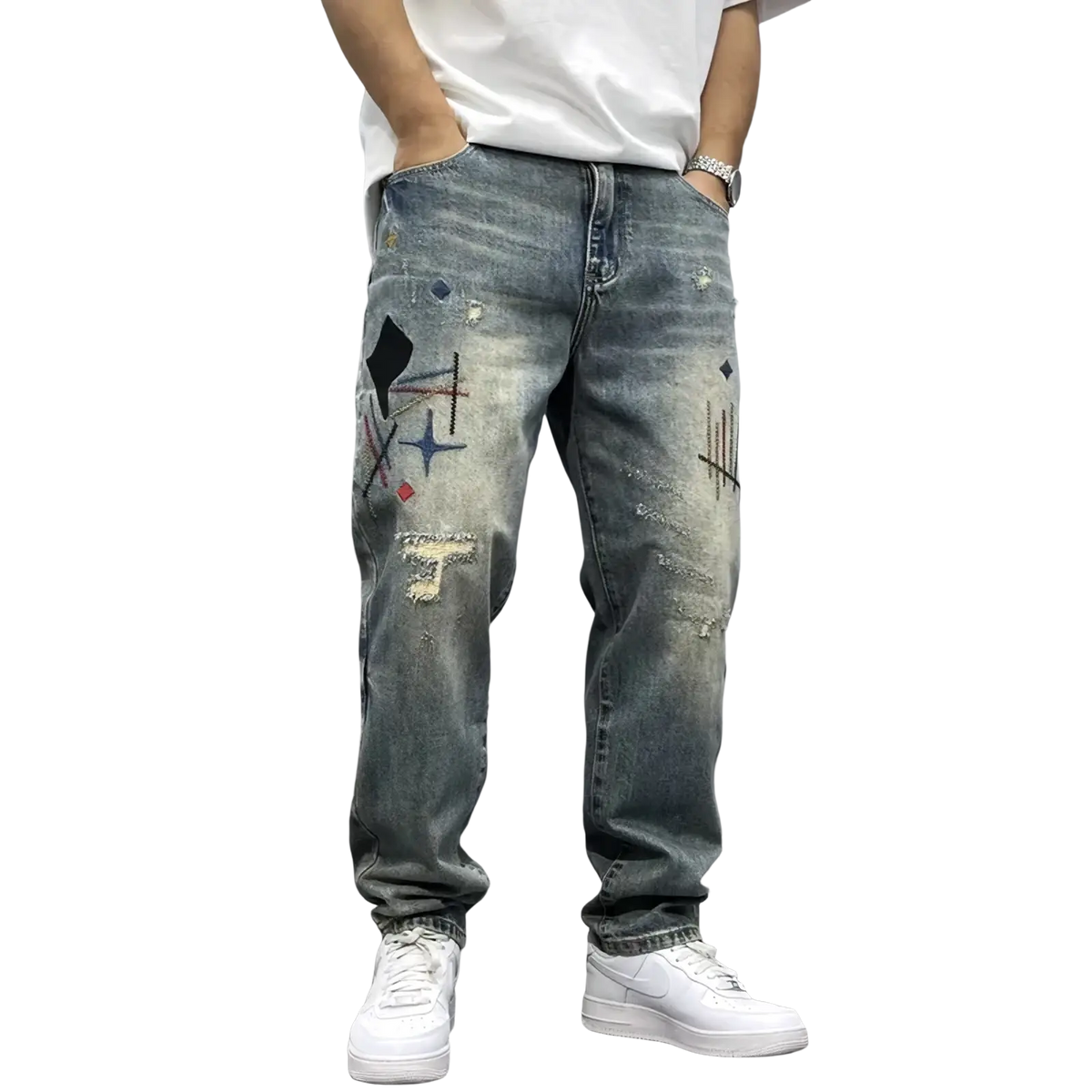 Men’s loose fit distressed straight leg denim jeans with light-wash fabric and colorful geometric graffiti patches on thighs