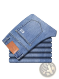 A stack of neatly folded light blue denim men’s loose straight leg retro washed jeans with brown leather patch on the waistband