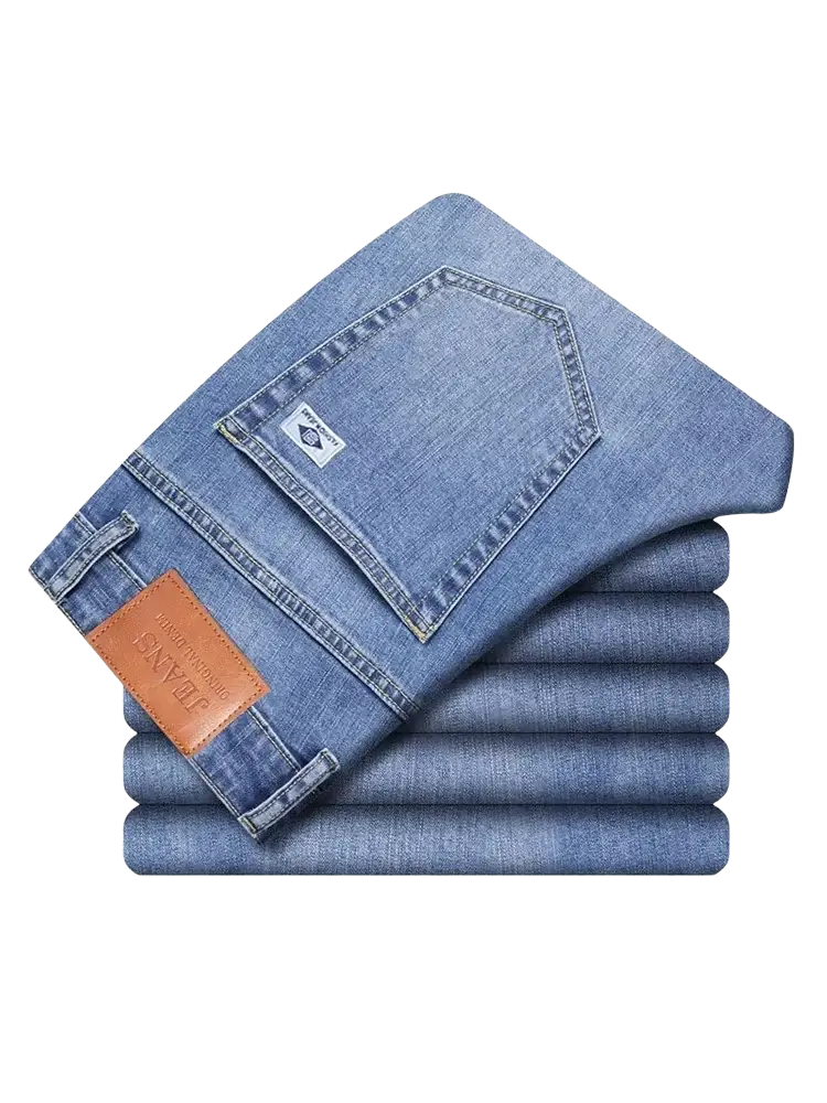 A stack of neatly folded light blue denim men’s loose straight leg retro washed jeans with brown leather patch on the waistband