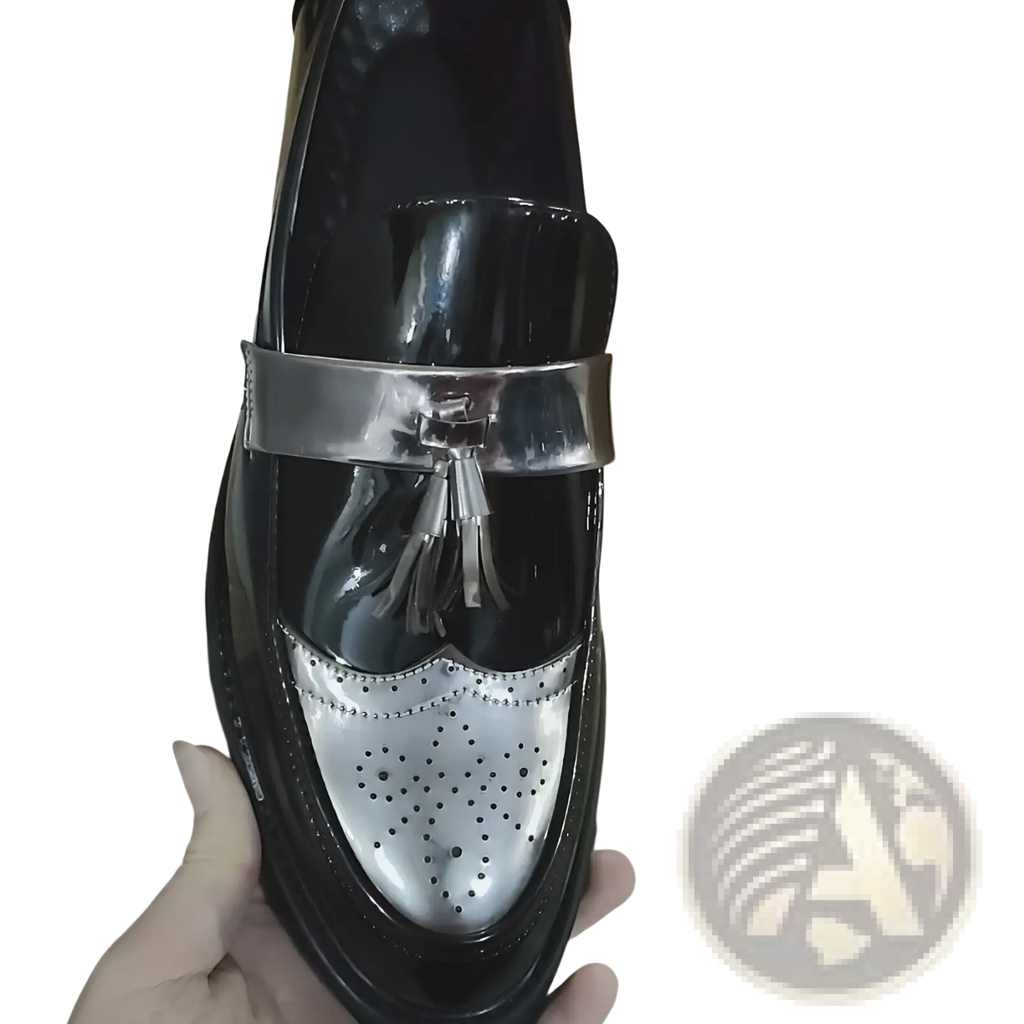 Men’s black and silver patent leather loafers with metallic strap and tassel detail displayed from the front