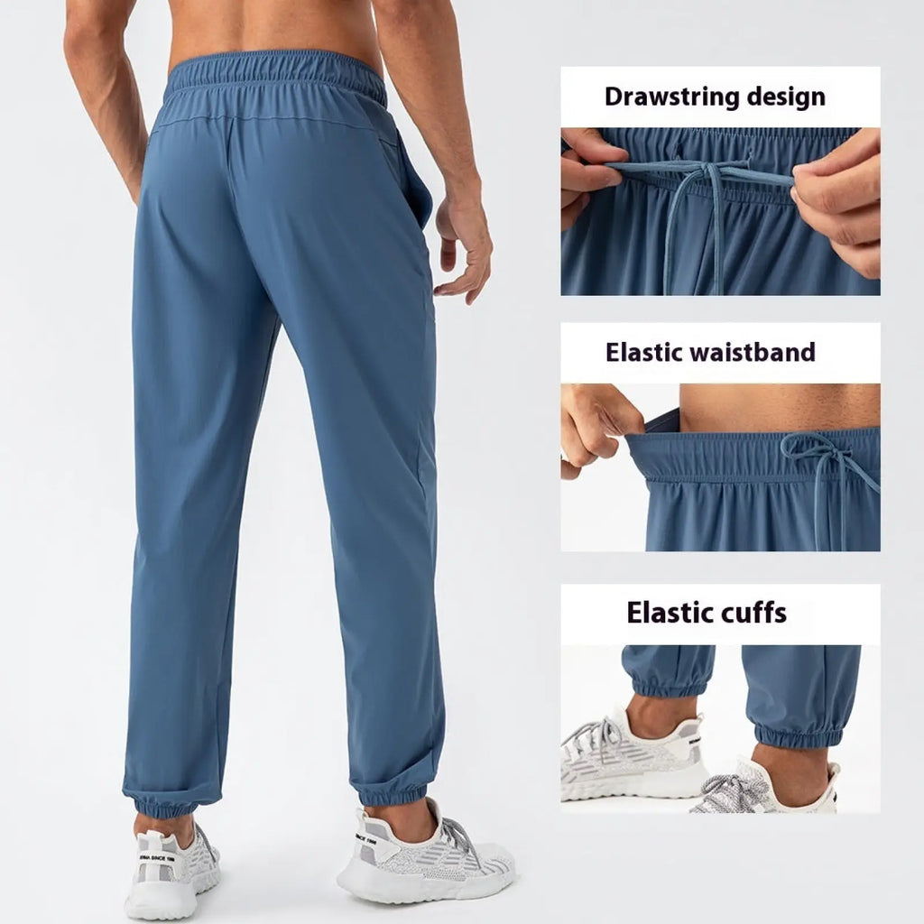 Men’s quick dry nylon loose fit athletic track pants in blue with elastic waistband, drawstring, and cuffed ankles