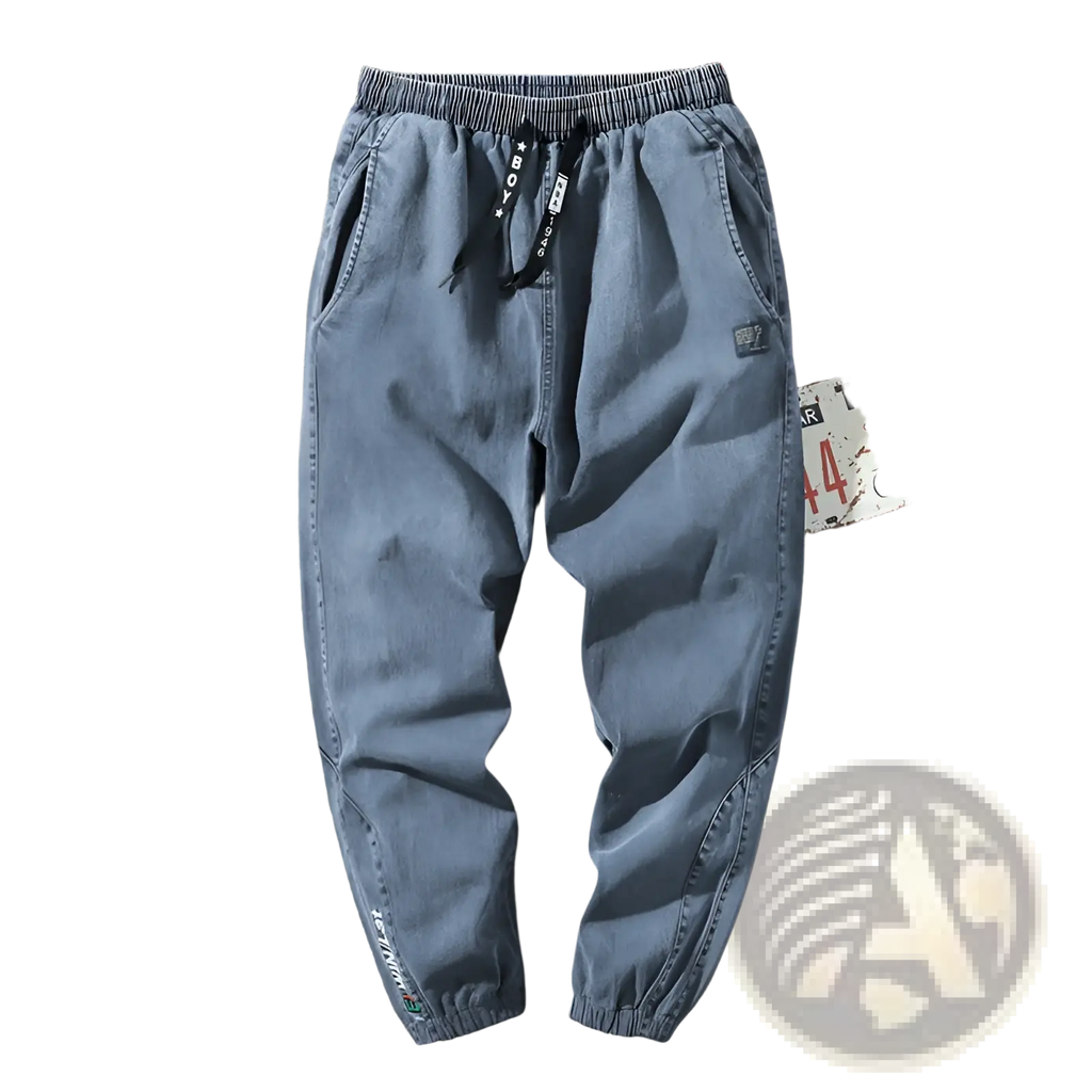 Men’s relaxed fit light blue denim joggers with elastic waistband black drawstrings patch and subtle cuff branding