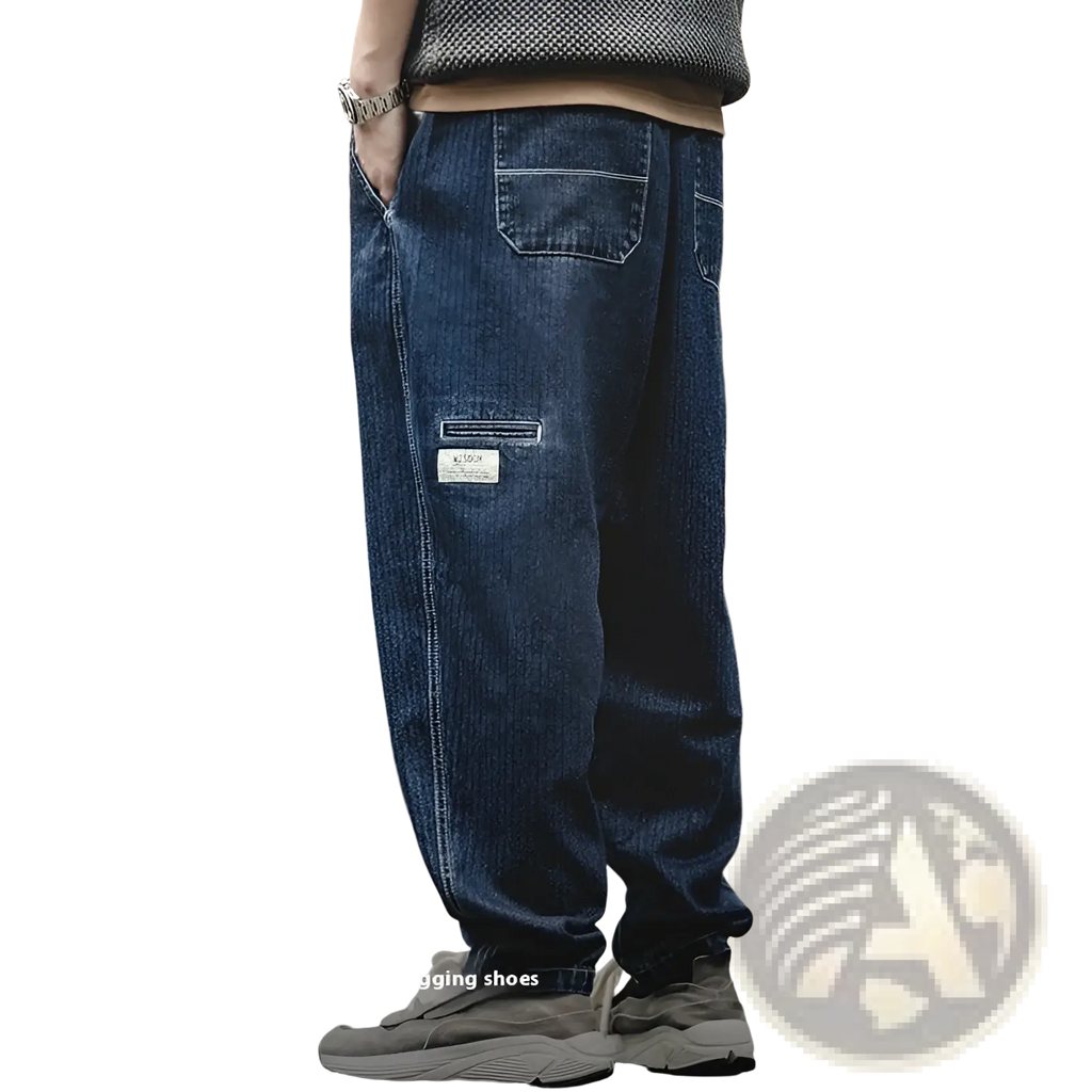 Men’s relaxed tapered dark blue denim jeans with visible stitching and a patch pocket on the thigh, front view