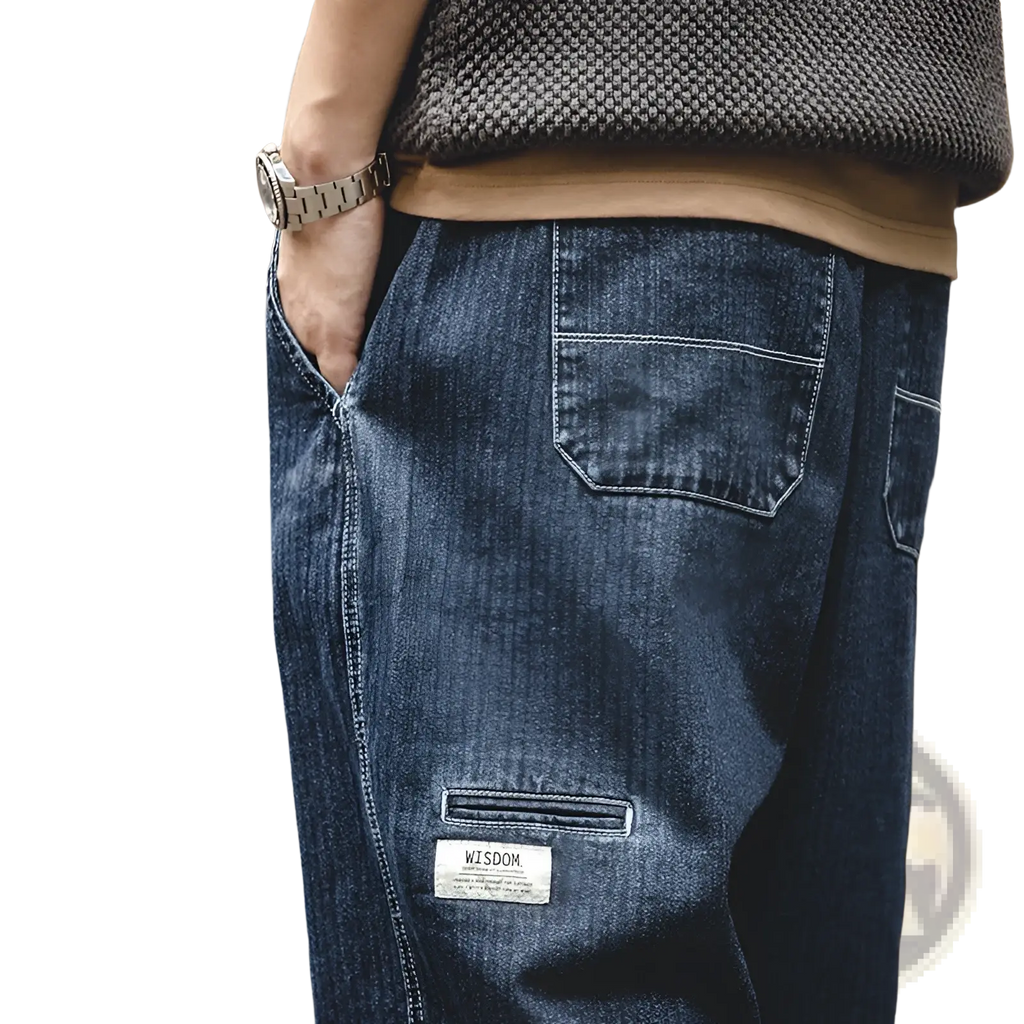 Men’s relaxed tapered dark blue denim jeans with patch pocket and white wisdom label on lower leg front side