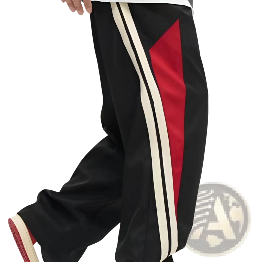 Men’s retro striped athletic track pants in black with bold red and cream vertical stripes along the side
