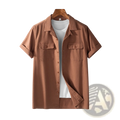 Brown men’s short sleeve cotton hemp workwear shirt with collar and two chest pockets hanging on wooden hanger