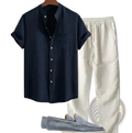 Navy blue short sleeve shirt and pants set with chest pocket and rolled cuffs displayed on wooden hanger