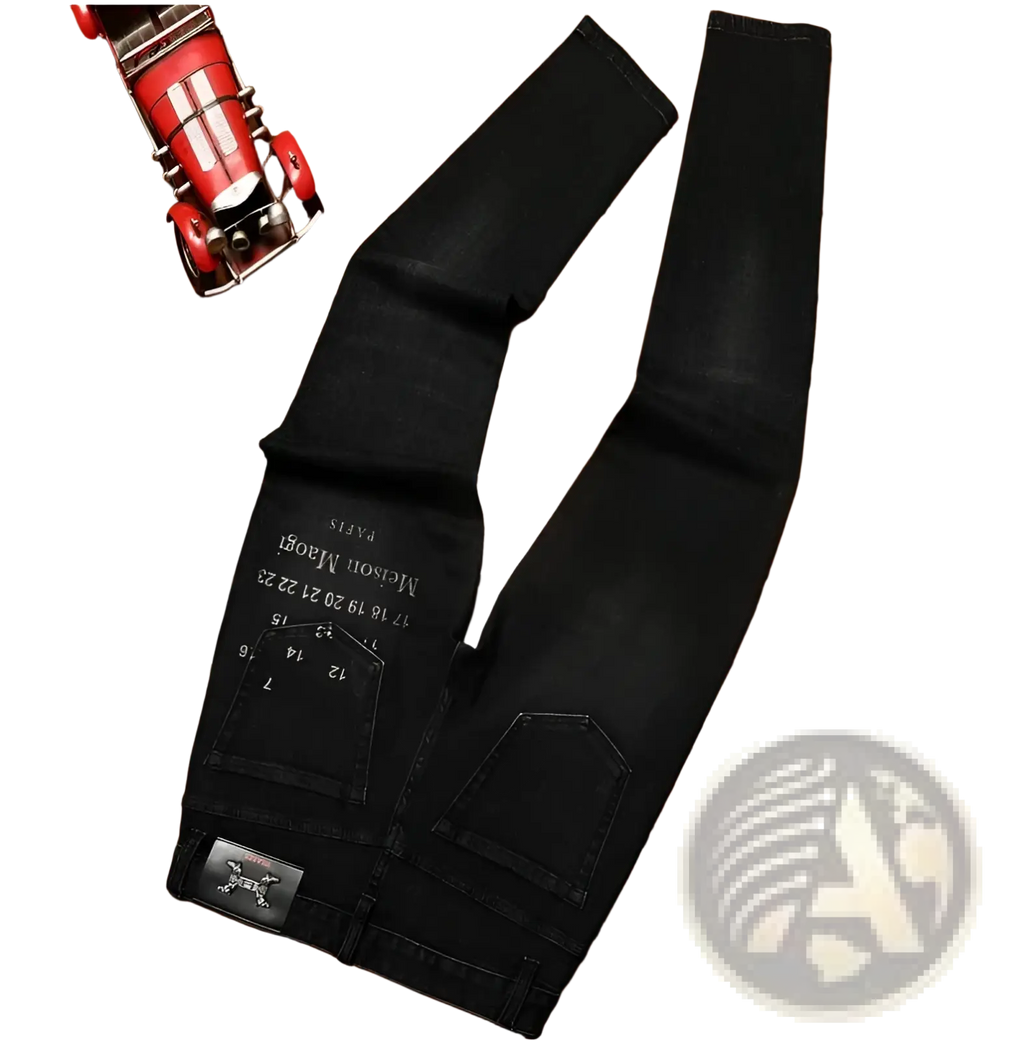 Mens slim fit printed black denim jeans shown from the back with white embroidered text and metallic skull patch on pocket