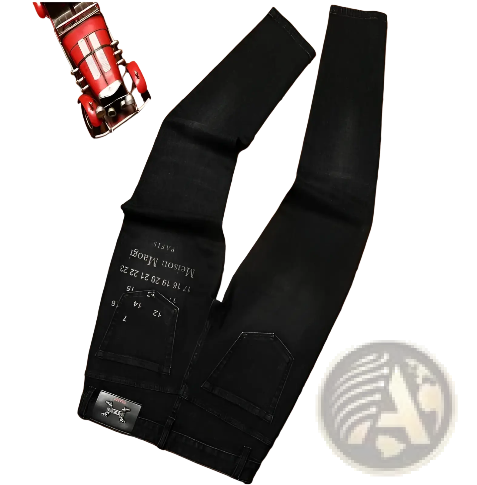 Mens slim fit printed black denim jeans shown from the back with white embroidered text and metallic skull patch on pocket