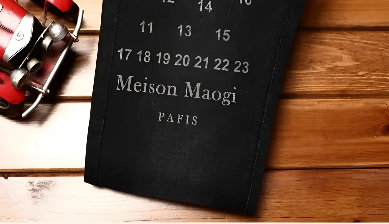 Mens slim fit printed black denim jeans shown alongside a black leather-bound calendar with silver embossed text and white dates