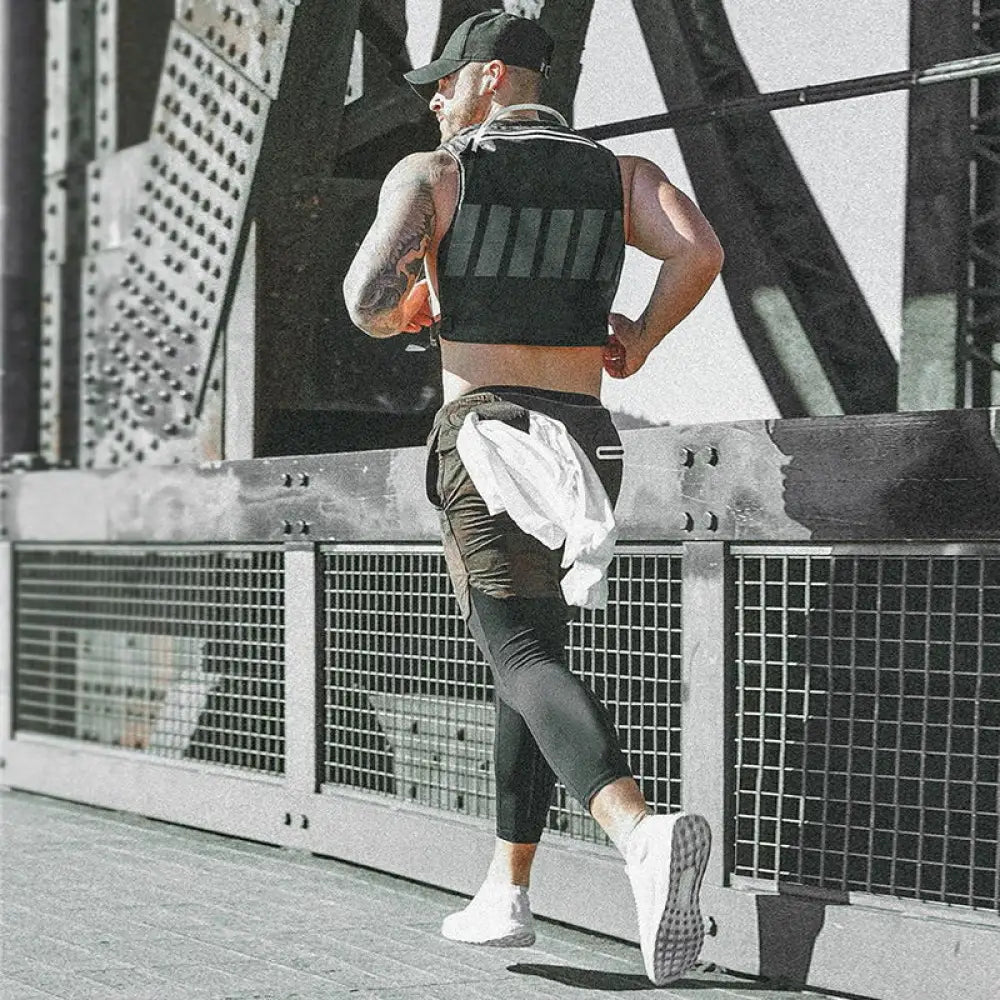 Black tactical vest with vertical gray stripes worn over a man’s torso paired with men’s camouflage quick dry 2-in-1 training shorts