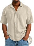 Men’s beige short sleeve button up shirt with textured ribbed fabric and white buttons