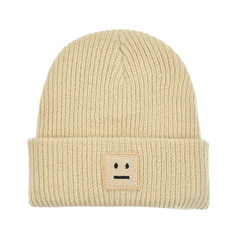 Beige ribbed knit men’s winter beanie hat with a square embroidered smiley face patch on the cuff