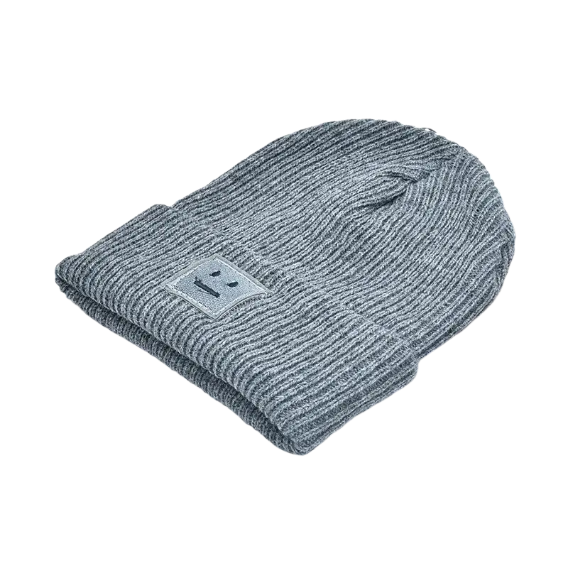 Gray ribbed knit men’s winter beanie hat with a small silver rectangular patch featuring a simple smiley face
