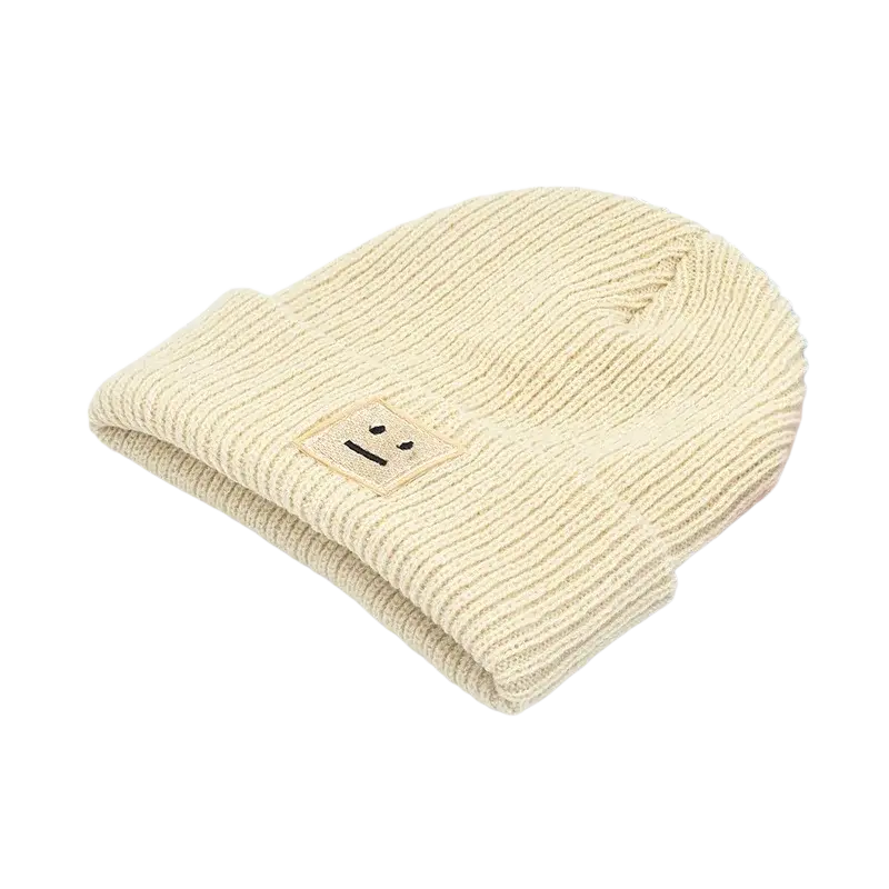 A soft cream-colored ribbed knit hat mens beanie with an embroidered smiley face patch for men’s winter use