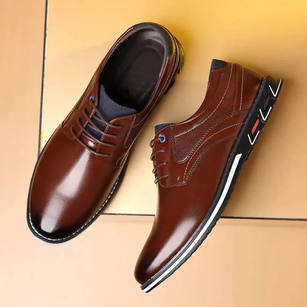 Men’s brown polished leather lace up work shoes with sleek finish and black soles featuring white and red accents