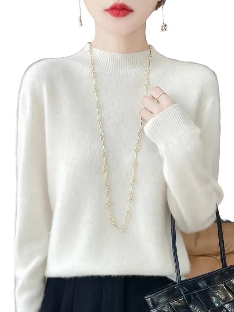 A delicate gold chain necklace with interlocking links worn over a white merino wool pullover sweater for women