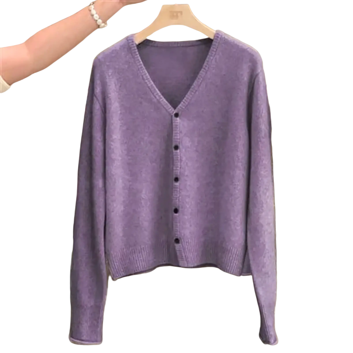 A soft lavender merino wool v-neck cardigan sweater with button closure hanging on a wooden hanger