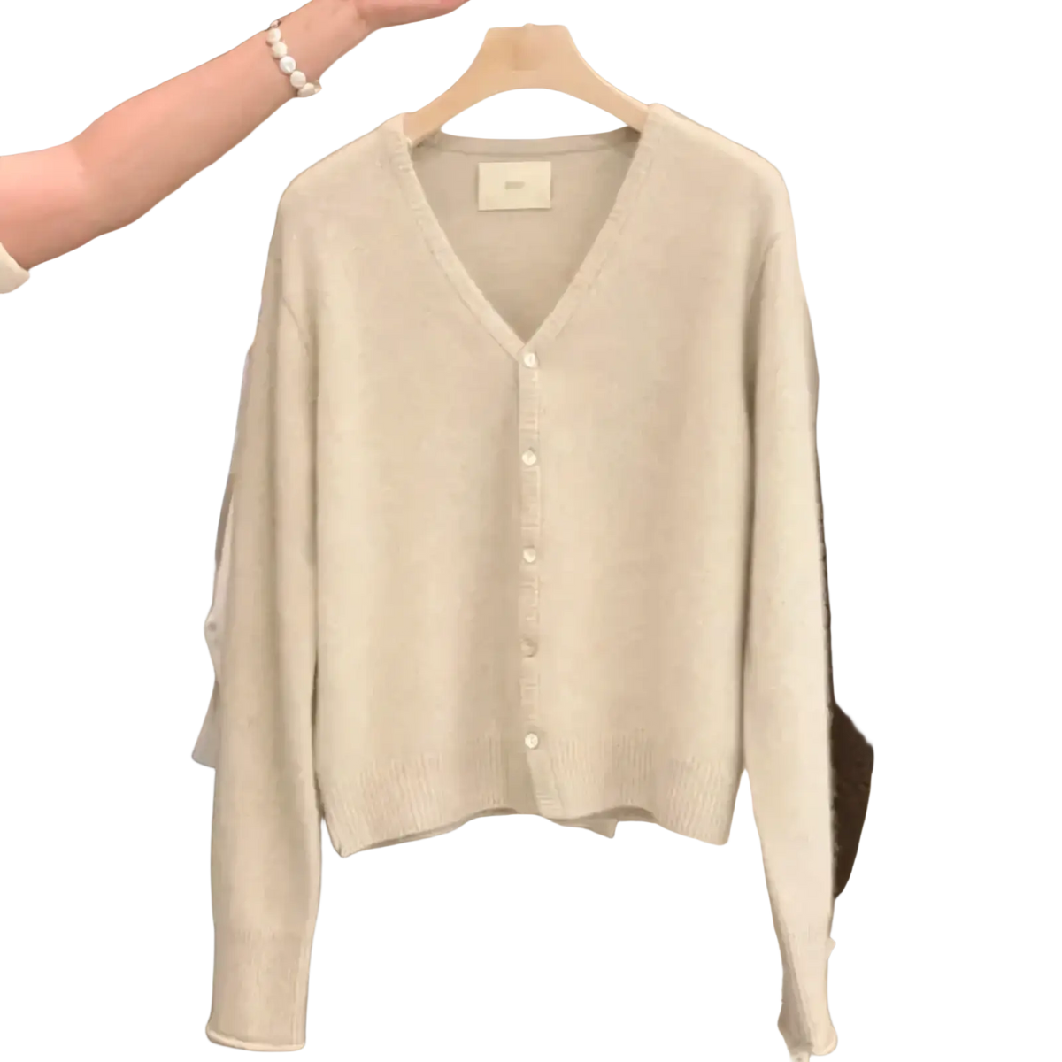 A soft off-white merino wool v-neck cardigan sweater with long sleeves and button-front closure