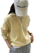 A soft pale yellow merino wool knit polo sweater for women with a v neck cozy texture and buttoned front