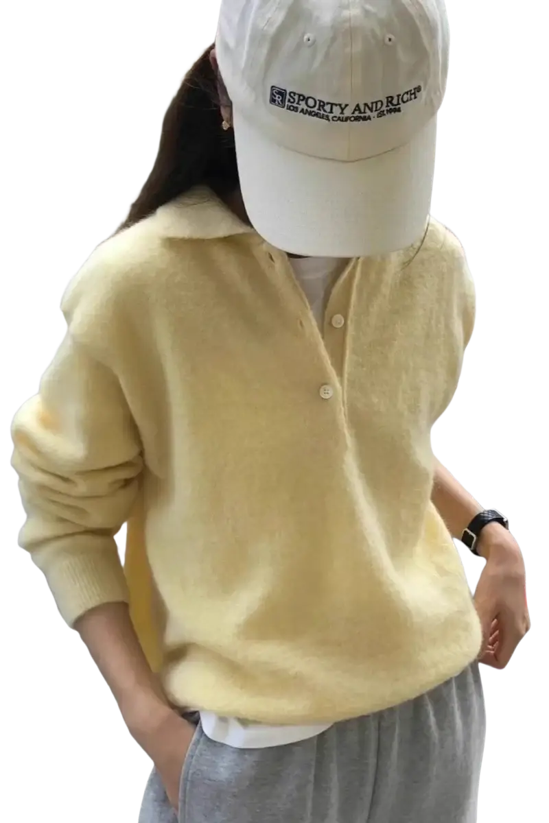 A soft pale yellow merino wool knit polo sweater for women with a v neck cozy texture and buttoned front