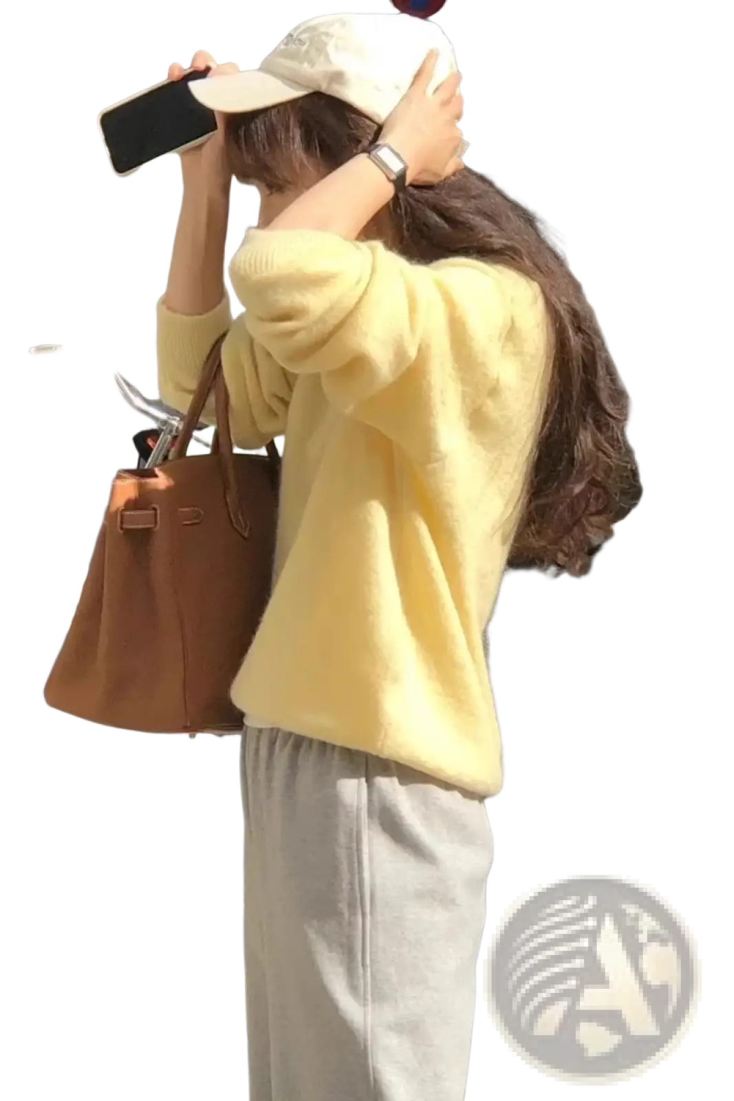A tan leather handbag with structured design and top handles shown alongside a merino wool v-neck women sweater
