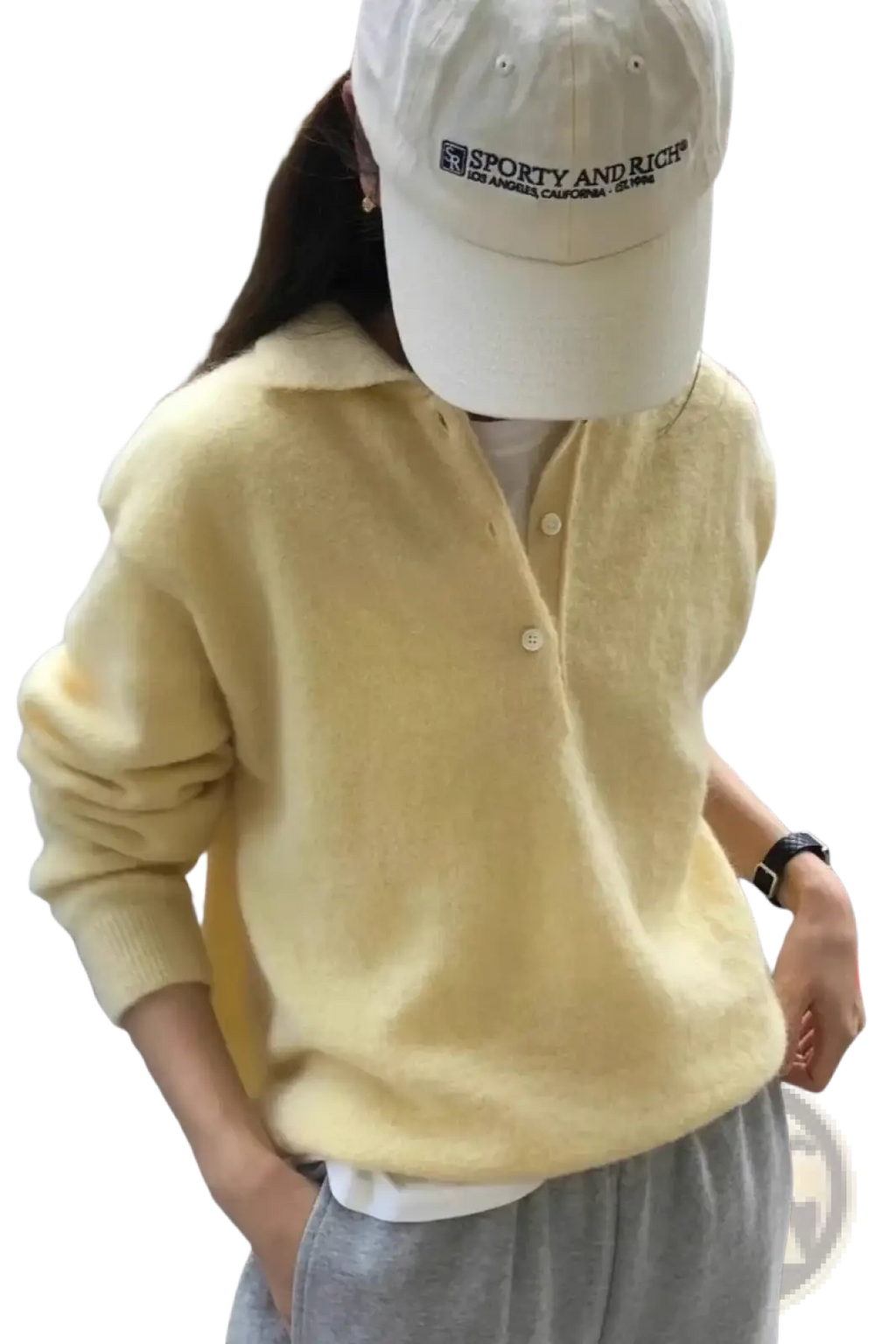 A soft pale yellow merino wool knit polo sweater for women with a cozy texture and buttoned front