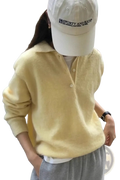 A soft pale yellow merino wool knit polo sweater for women with a cozy texture and buttoned front