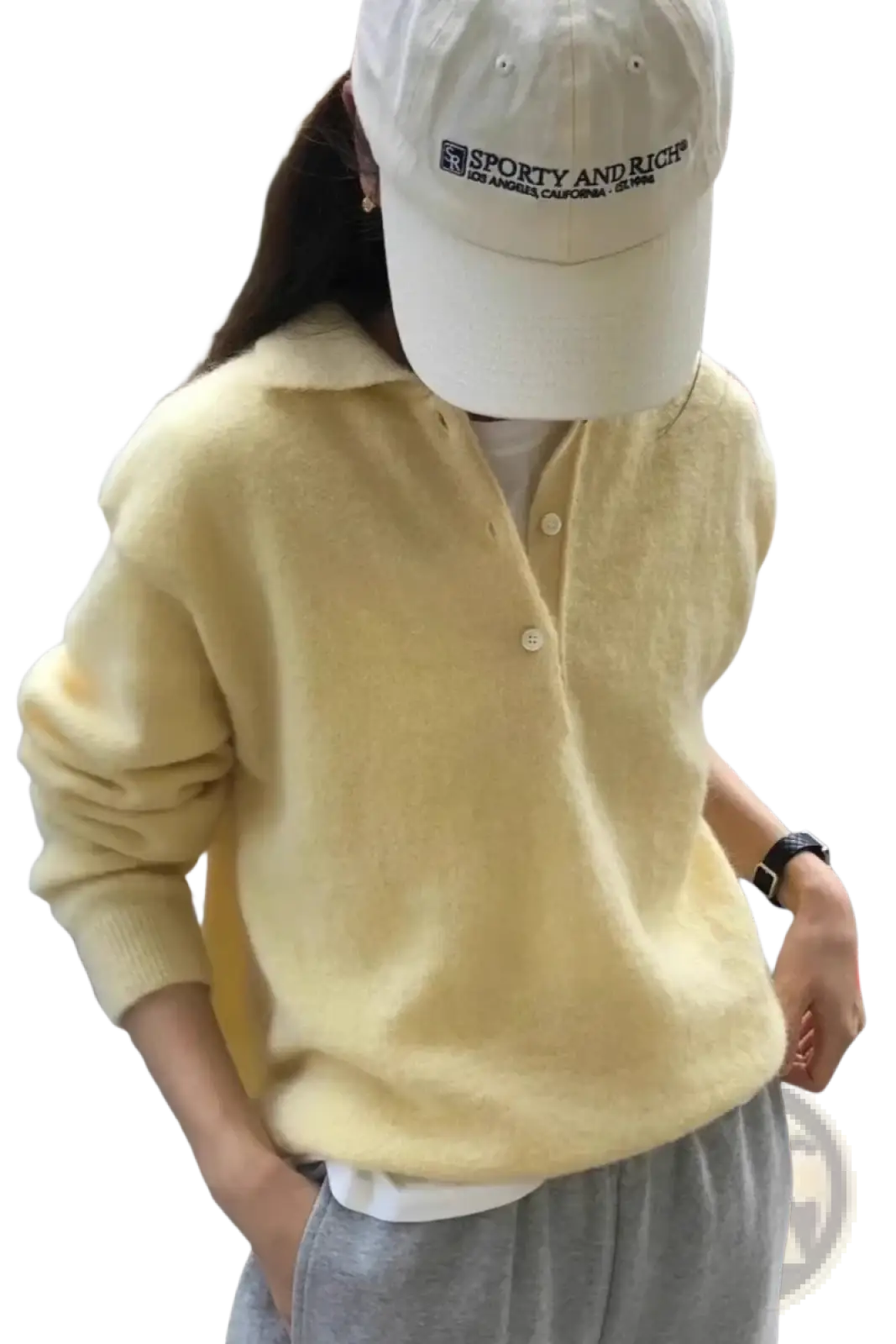 A soft pale yellow merino wool knit polo sweater for women with a cozy texture and buttoned front