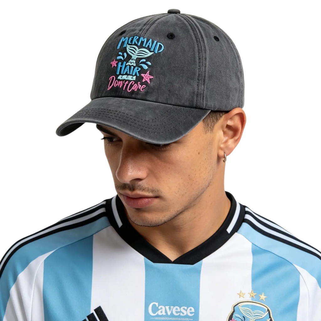 A dark gray distressed cotton baseball cap with embroidered mermaid hair dont care text in blue and pink with stars