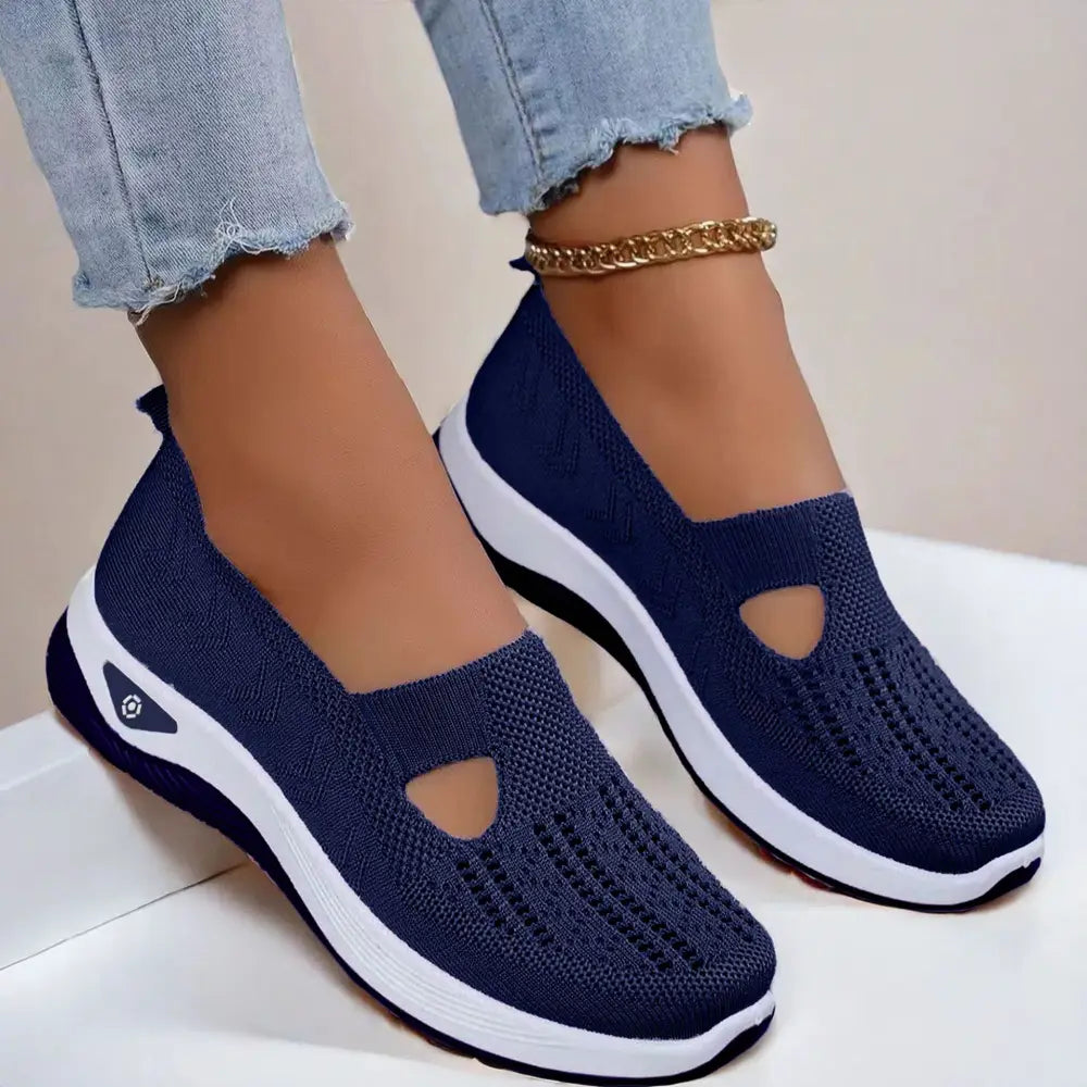 Navy blue knit breathable mesh slip-on casual flats with white and black soles and decorative cutout on the toe