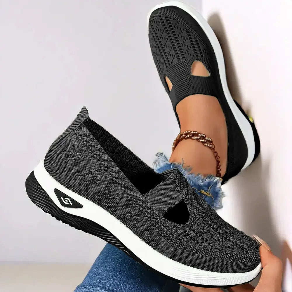 Women’s breathable black mesh slip-on casual flats with white rubber soles and a triangular logo on the side