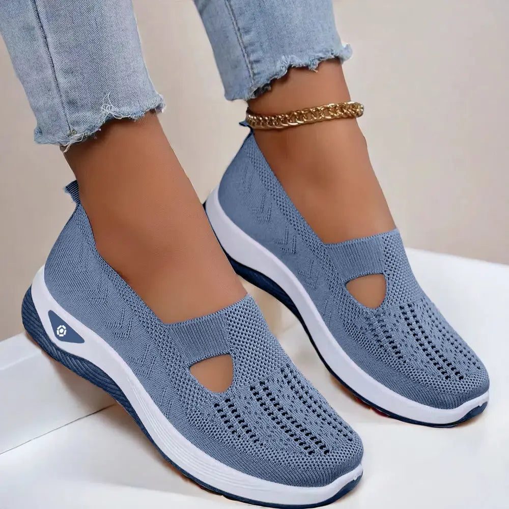 Light blue knitted women’s breathable mesh slip on casual flats with white and navy rubber sole featuring perforations
