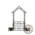 Black wrought iron metal garden arch with decorative lattice gate bench and floral planters on either side