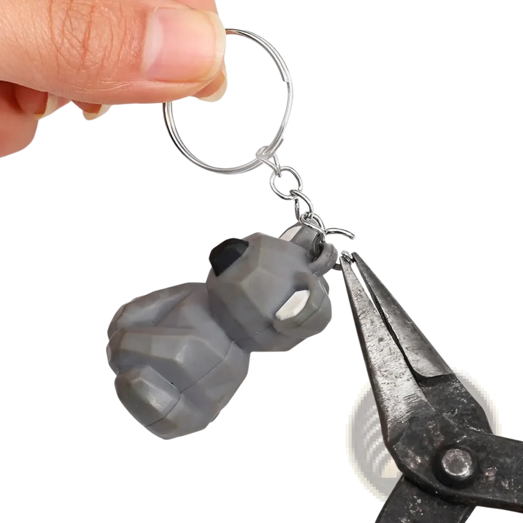 Gray faceted rubber metal keychain shaped like a stylized grenade with black and white accents and split ring chain