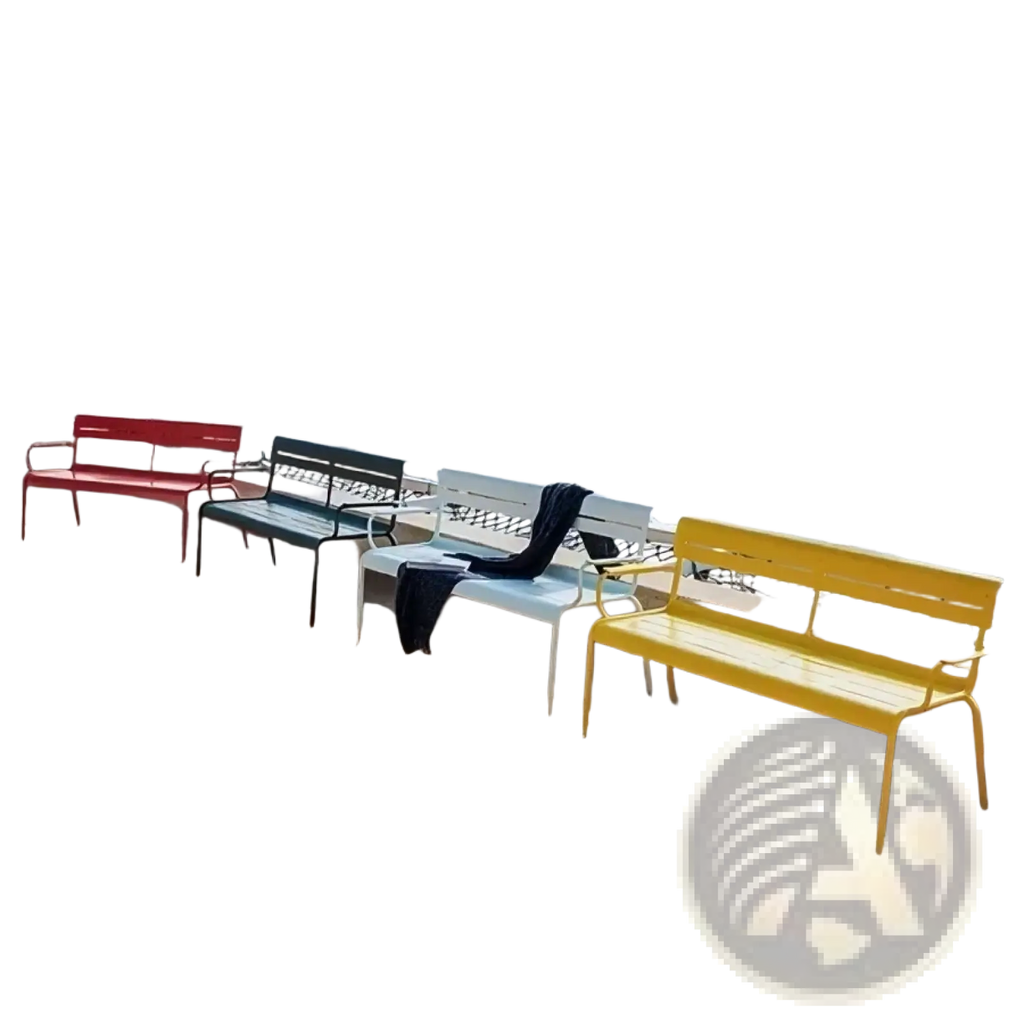 Brightly colored metal outdoor garden benches in red green and yellow with modern slatted design on sandy beach