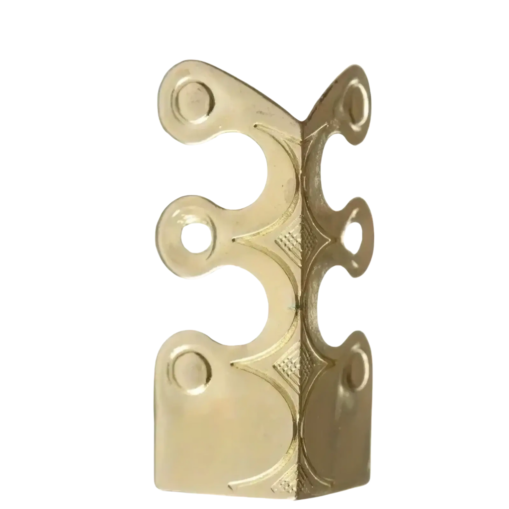 Gold-colored brass corner hinge with ornate cutouts and embossed diamond pattern for metal skirting board corner protection