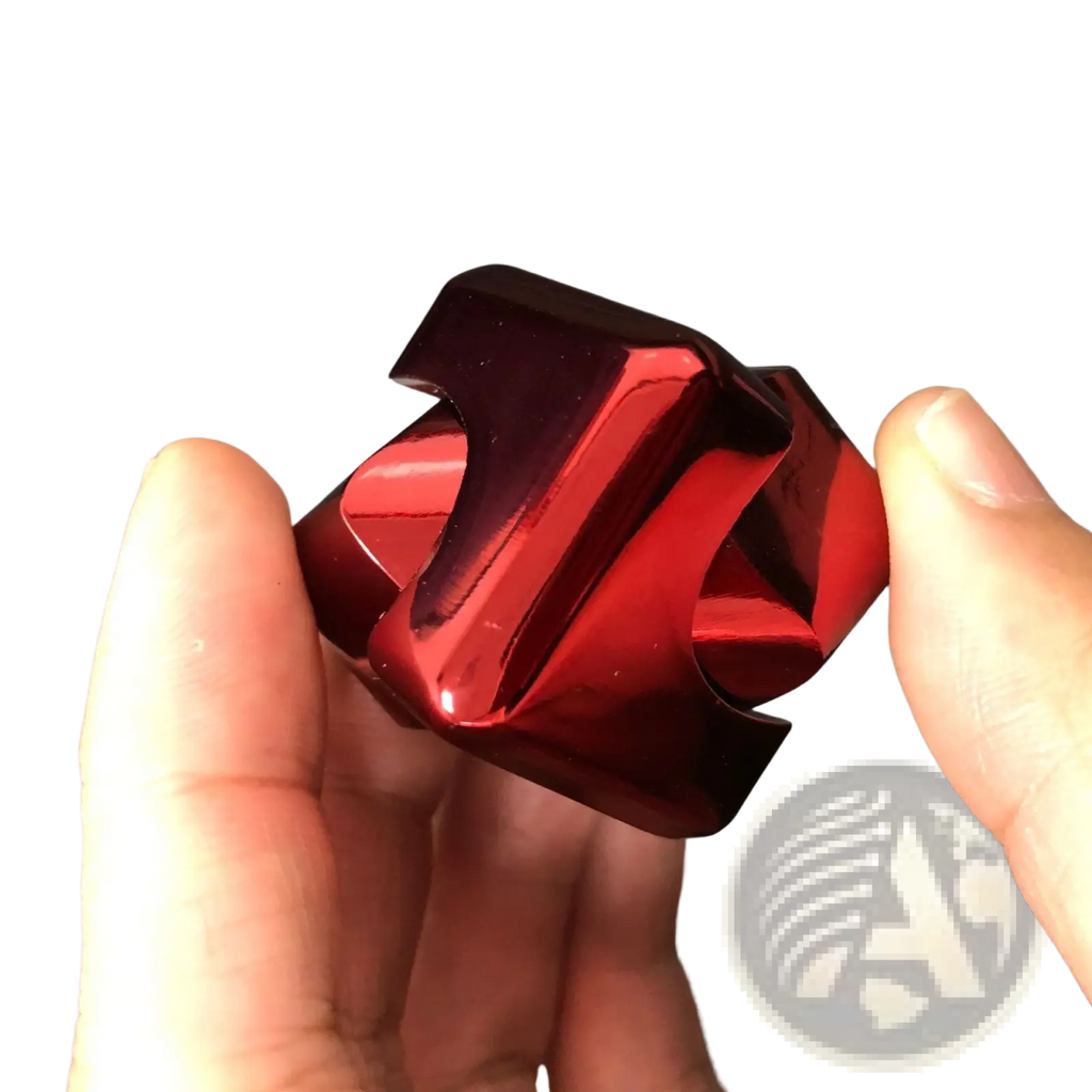 A glossy red metallic fidget cube with angular interlocking segments for stress relief toy use