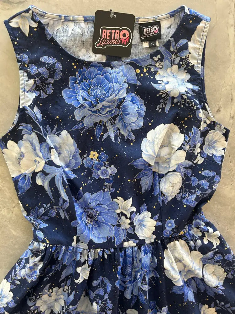 A navy blue sleeveless 1950s vintage cotton dress with metallic floral pattern featuring peonies and gold speckles