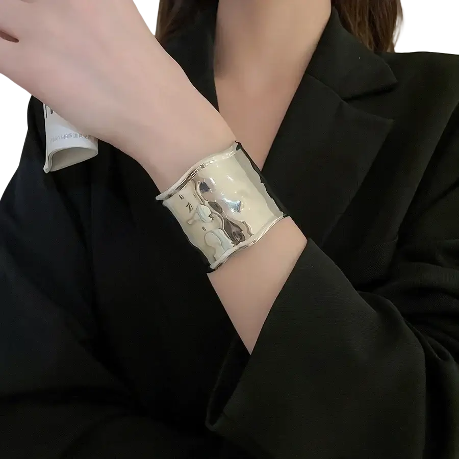 A wide silver-toned metallic pleated cuff bracelet for women with glossy white enamel and subtle metallic accents