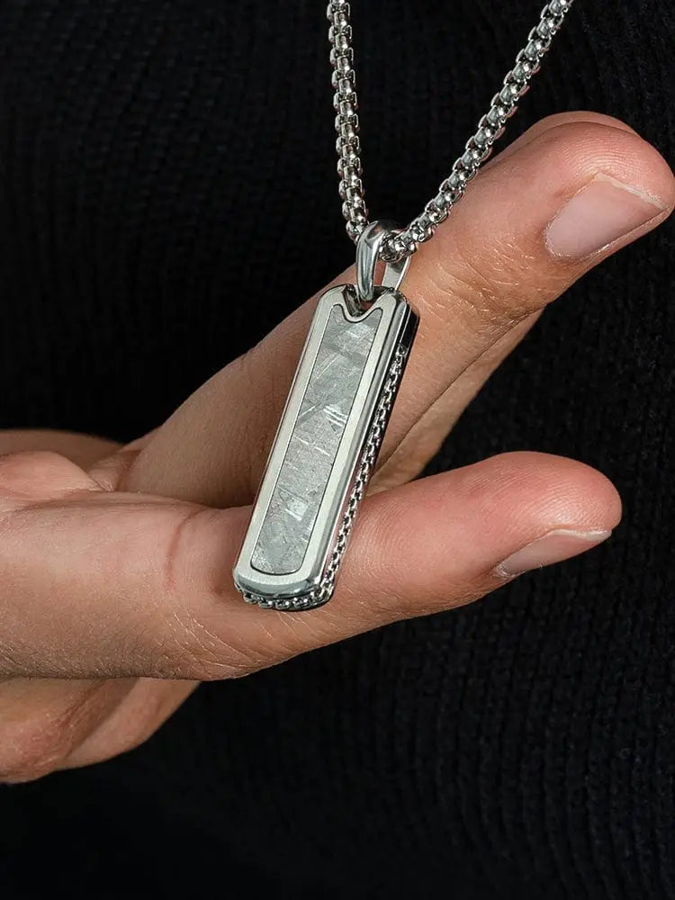 Silver rectangular Muonionalusta meteorite stainless steel pendant necklace with textured metallic interior and beaded edges