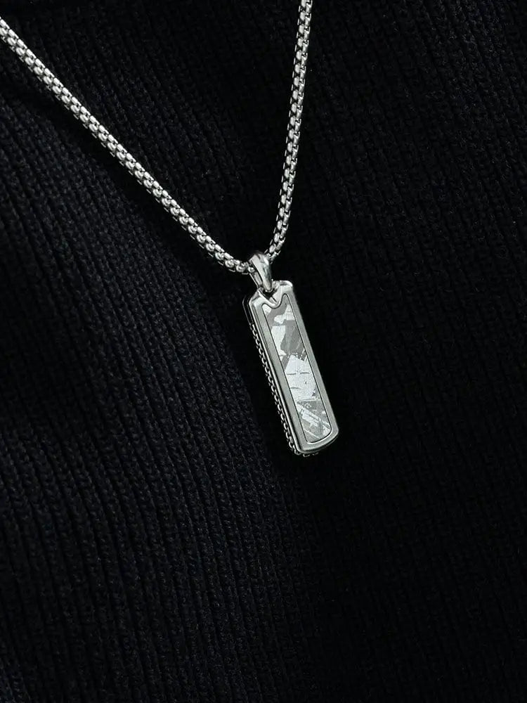 Silver rectangular stainless steel pendant with textured surface and natural Muonionalusta meteorite inlay