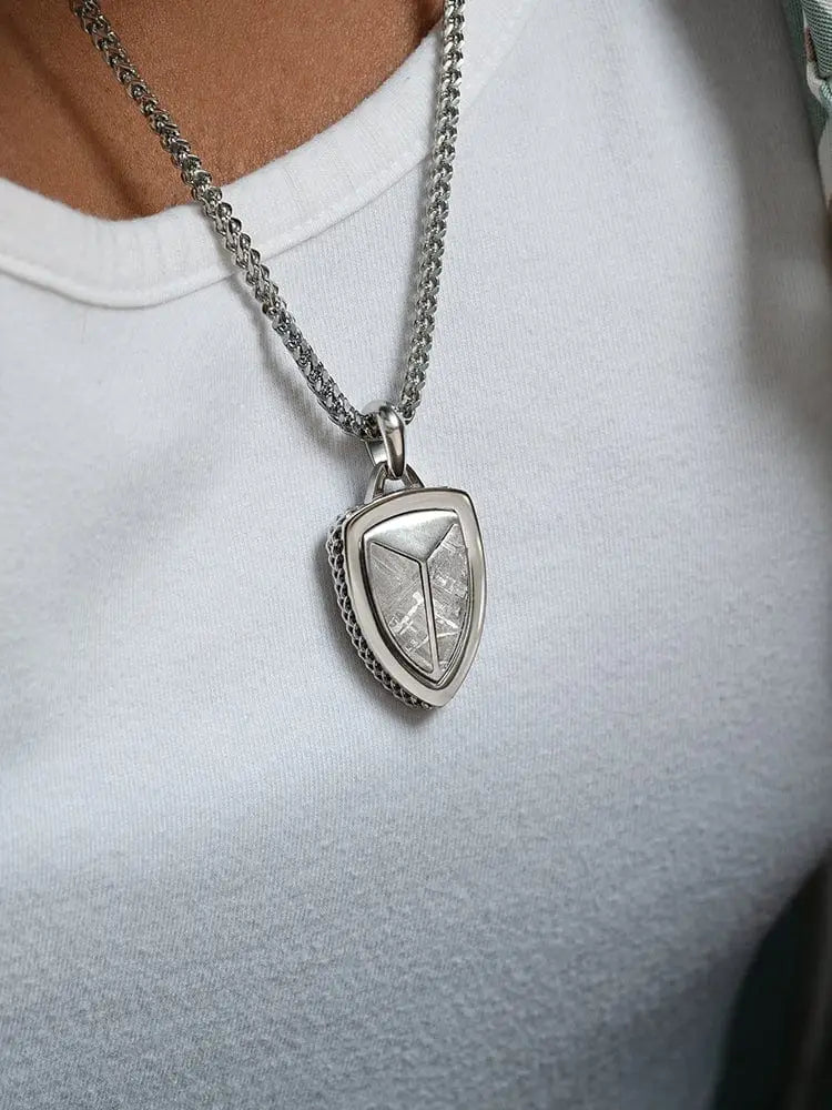 Silver shield pendant with textured metallic surface and intricate edges muonionalusta meteorite on wheat chain