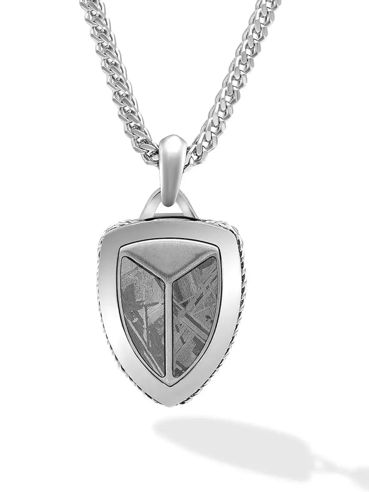 Silver muonionalusta meteorite shield pendant with textured metallic interior and braided edge on wheat chain