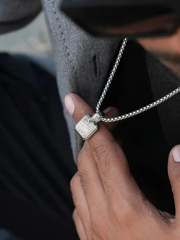 Silver-toned rectangular Muonionalusta meteorite pendant with textured wood-grain pattern on stainless steel box chain necklace