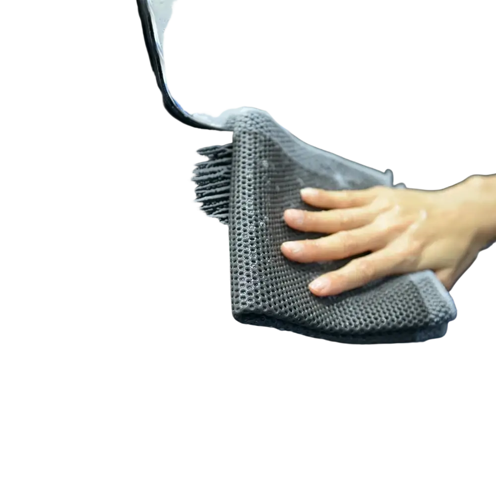 Gray textured microfiber car clay towel detailing cloth used as a mitt to scrub a black vehicle surface gently