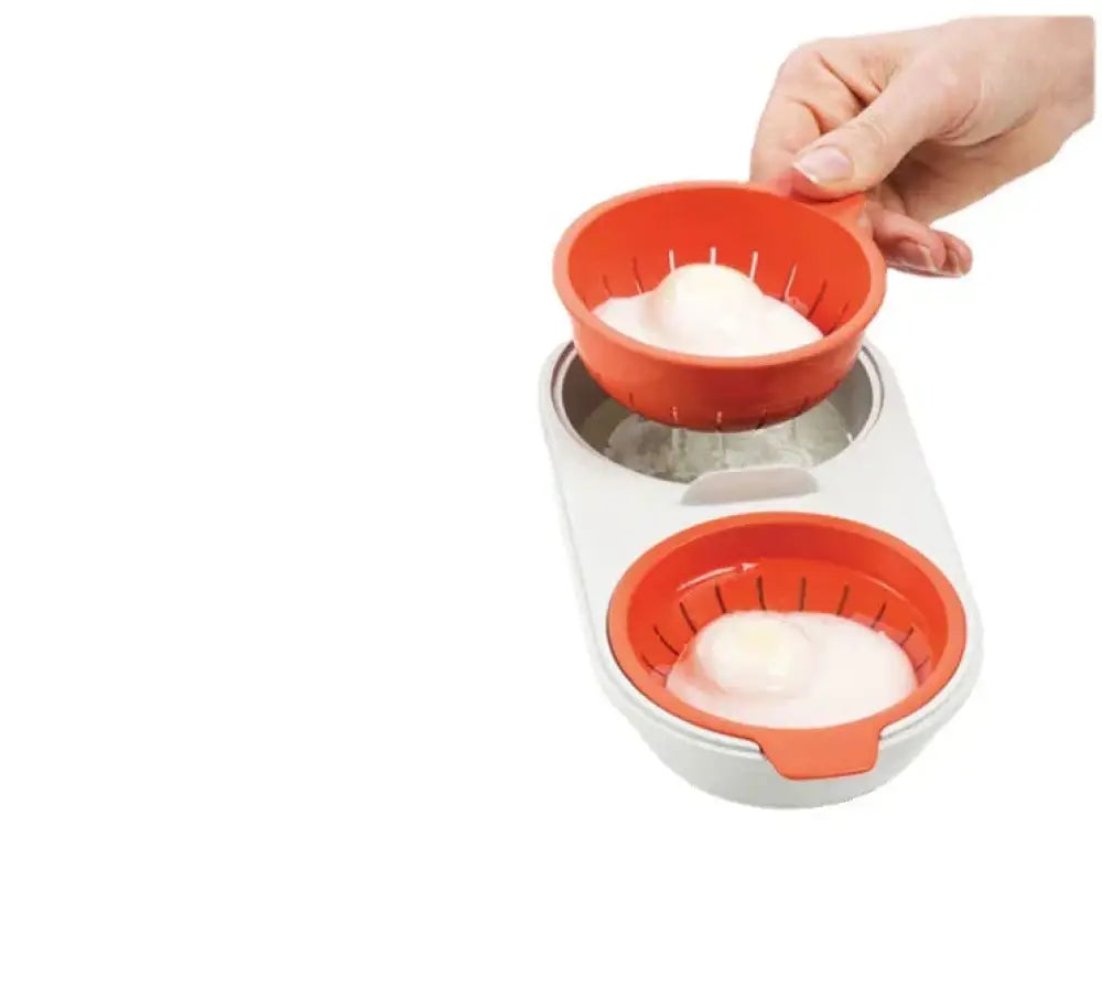 Orange and white microwave double cup egg poacher and boiler with two compartments each holding a cracked egg
